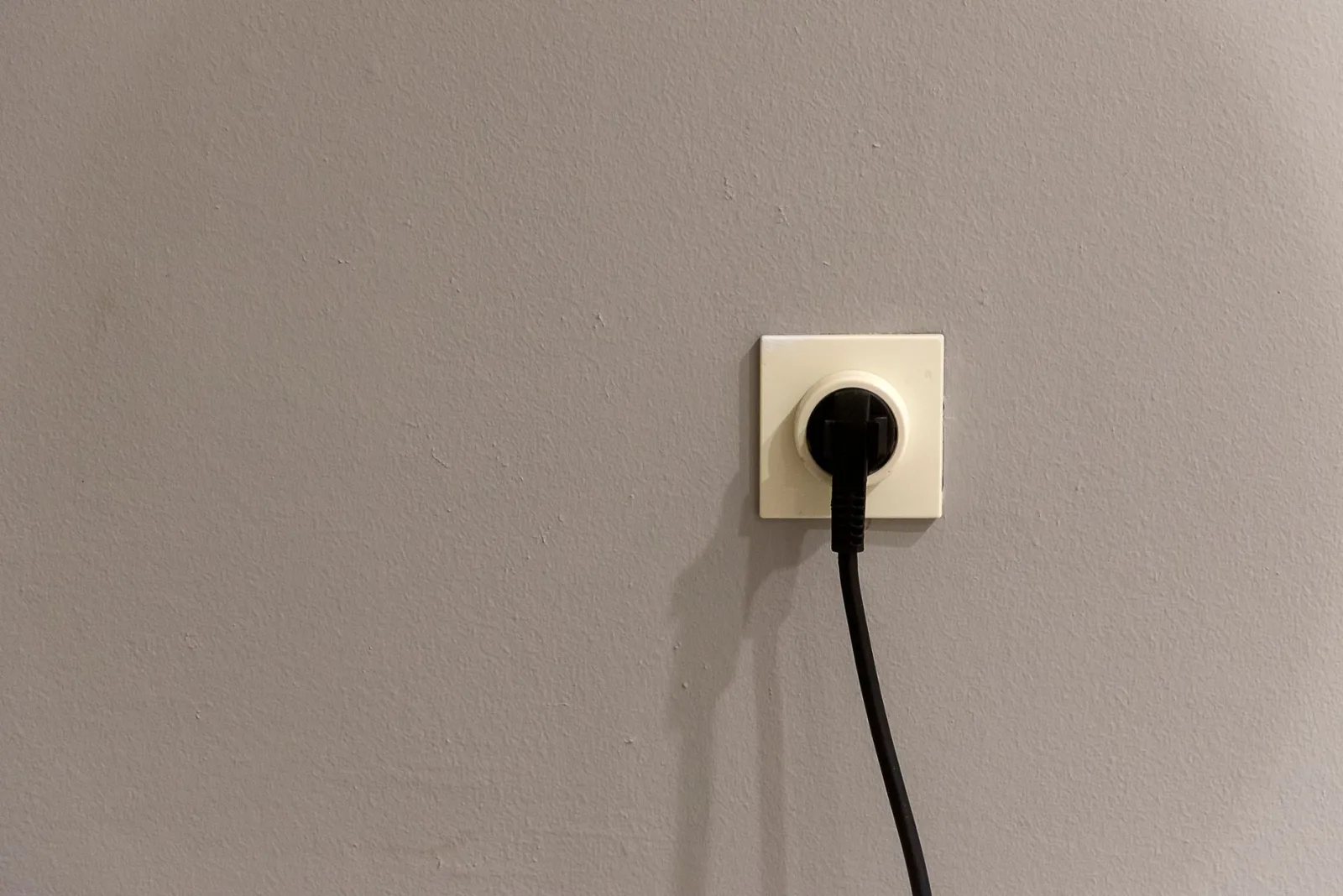 Pojedyncze gniazdko z wtyczką wsuniętą, kabel opada w dół, brak iskry